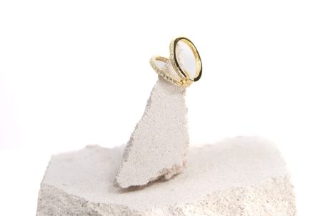 Zwei Eheringe aus Gold auf einem weißen Steinpodest.