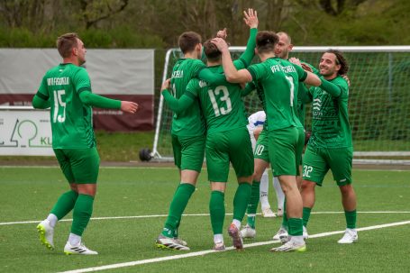 Fußballmannschaft feiert ein Tor auf dem Spielfeld.